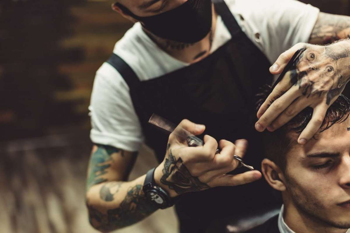 Crop barber doing haircut for client