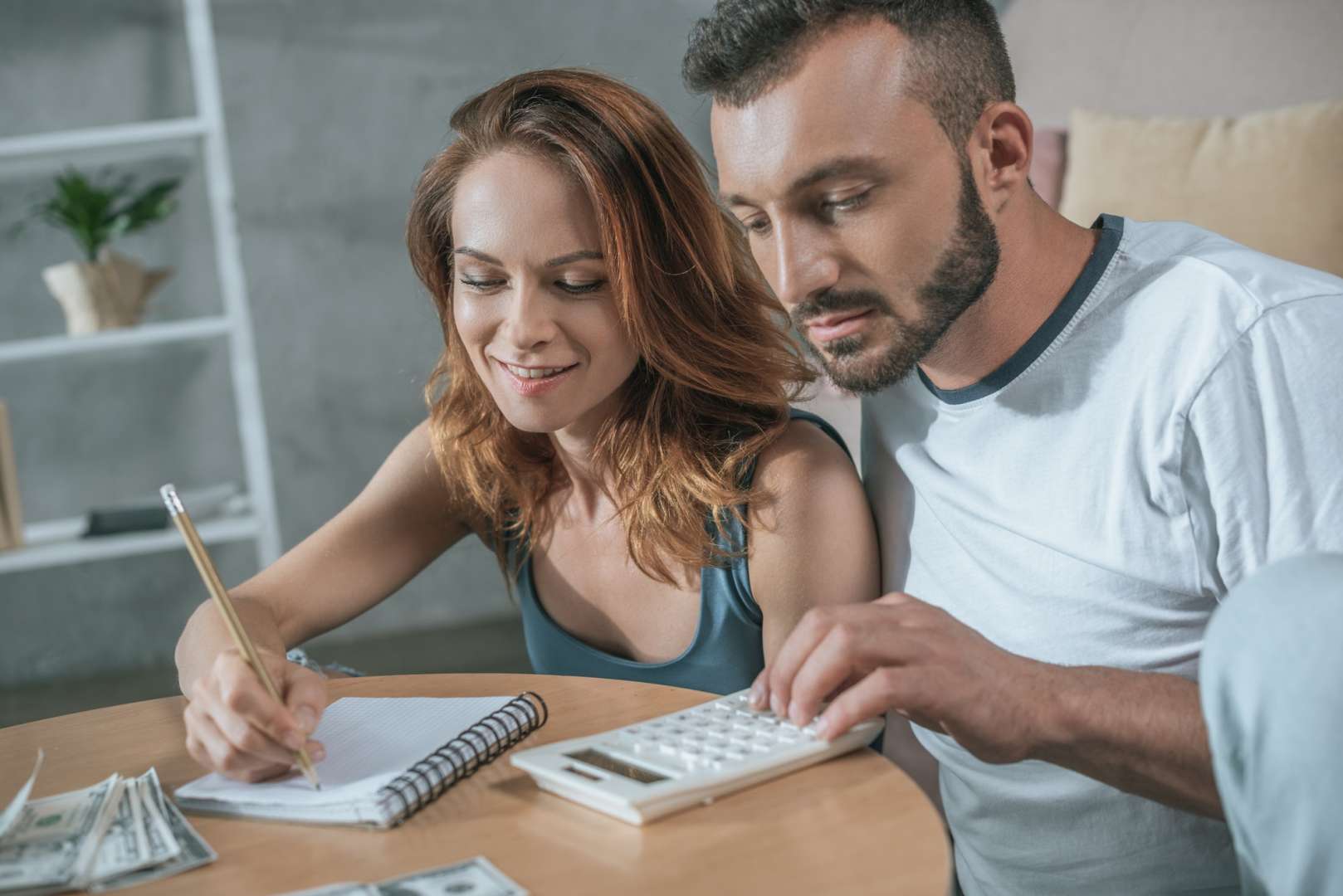 couple planning family budget with notebook and calculator in living room