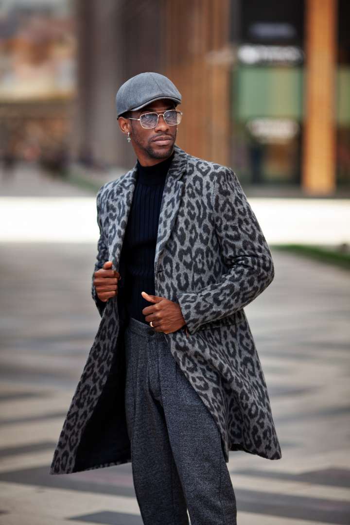Man in animal-print overcoat, turtleneck sweater, and loose, full trousers