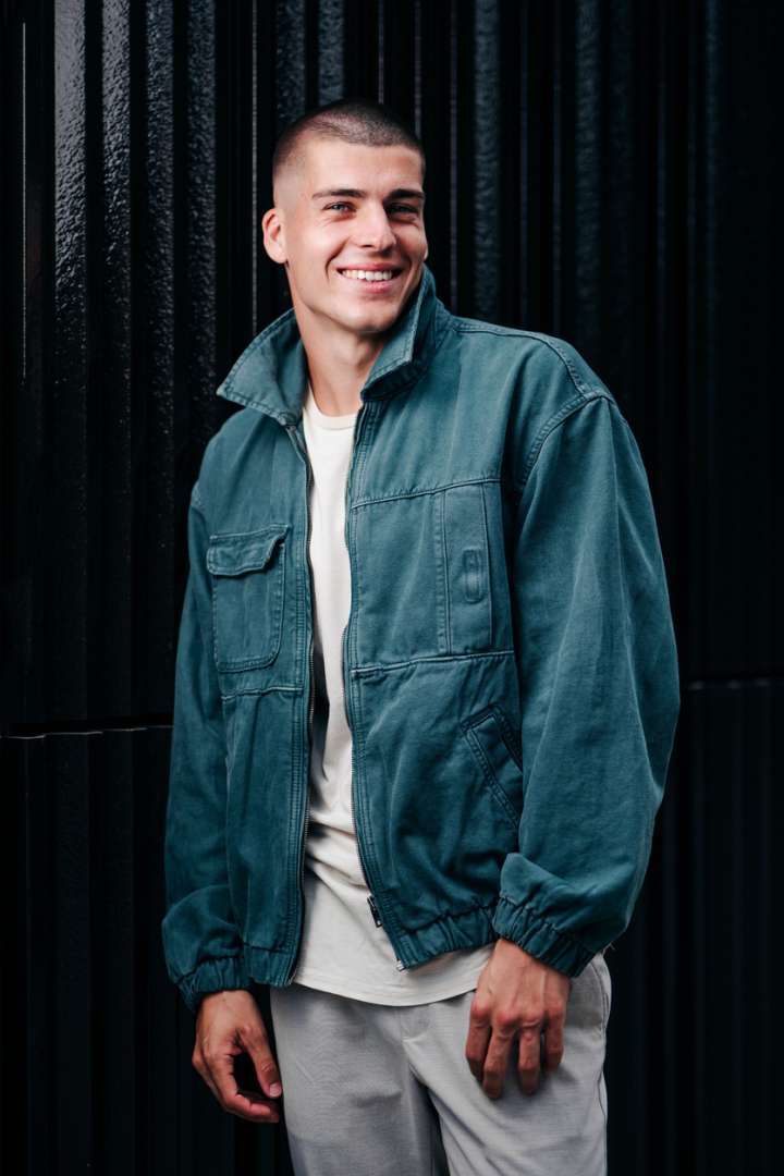 Young smiling man in a utility-inspired jacket 